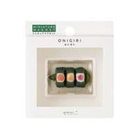 Onigiri-shaped miniature magnet packaging with visible brand name.